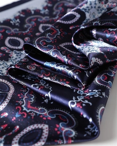 Gros plan d'un foulard en satin bleu marine avec motifs paisley et texture soyeuse