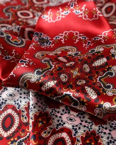Gros plan sur un foulard en satin de soie à motif Paisley avec texture brillante et rouge