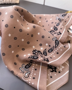 Close-up of paisley pattern and herringbone texture on the soft brown square scarf