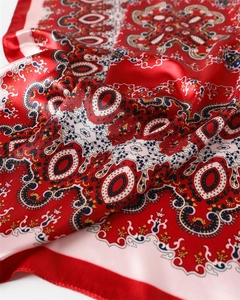 Vue détaillée de la texture du foulard en satin cachemire rouge avec drapé élégant