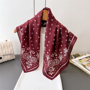 Close-up of paisley pattern on burgundy satin scarf with star floral prints