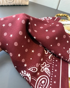 Detail of burgundy paisley cotton-linen scarf with white floral star patterns