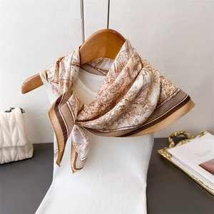 Gros plan du foulard en lin beige avec imprimé paysage marron sur un débardeur blanc
