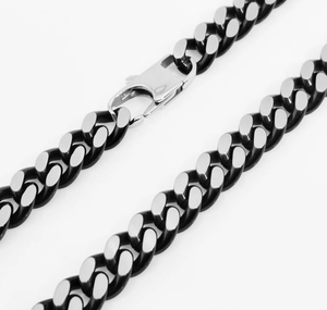 Macro shot of silver and black polished stainless steel cuban chain with lobster clasp