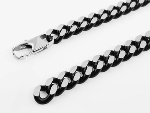 Macro detail of silver and black Cuban link chain with a large lobster clasp for men