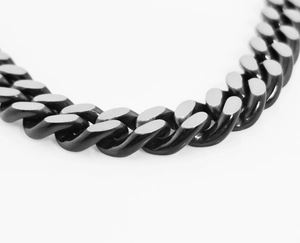 Macro shot of heavy Cuban link chain showing brushed matte and high-polish steel texture