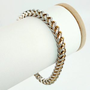 Dettaglio del bracciale hip hop bicolore oro e argento su espositore in pelle