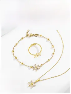 Vue détaillée du service de bijoux fleurs dorées avec cristaux blancs et perles