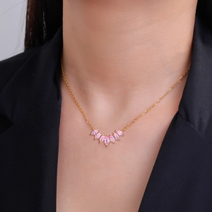 Collier élégant en or avec pendentif épi en zircon rose porté par un mannequin