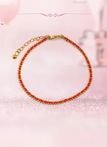 Detailansicht eines handgefertigten roten Armbands mit Goldperlen und Karabinerverschluss