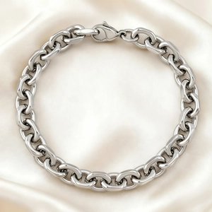 Polished stainless steel chunky chain bracelet with lobster clasp on beige satin fabric