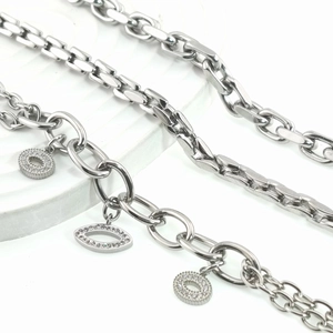 Detail of assorted stainless steel bracelets featuring chunky links and rhinestone charms