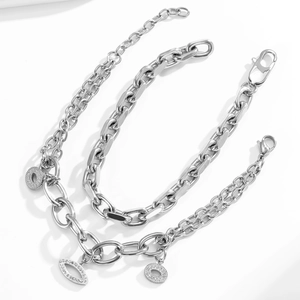 Detail of stainless steel curb chain with pave-set cubic zirconia geometric charms