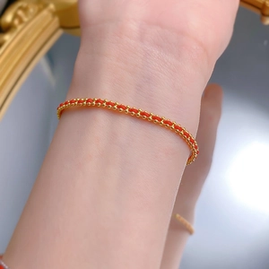 Handgefertigtes rotes Armband mit 18K Goldperlen für Glück am Handgelenk