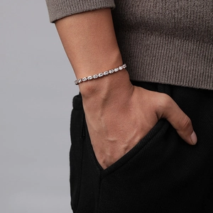 Bracelet tennis classique avec oxydes de zirconium ronds porté au poignet d'un homme
