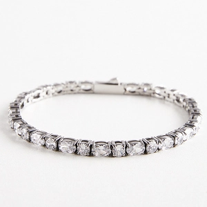 Détail macro d'un bracelet tennis argenté avec zircons ovales et fermoir pliable