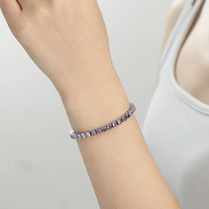 Bracelet tennis argenté avec zircons lavande, porté élégamment au poignet d'un mannequin