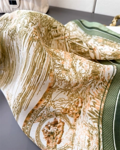 Détail du motif Toile de Jouy sur le tissu soyeux d'un foulard vert émeraude