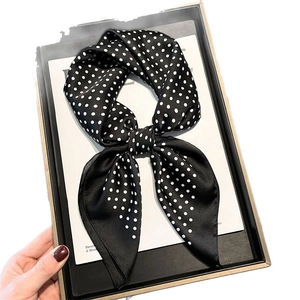 Elegant polka dot silk scarf in a bow shape presented in a minimalist gift box