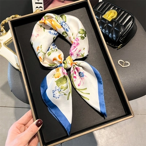 Floral print silk-like scarf with blue borders in a decorative bow arrangement