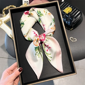 Floral print satin silk scarf with pink roses elegantly styled on a black display tray