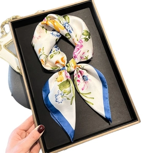 Floral print silk square scarf with blue borders displayed in a luxury black tray