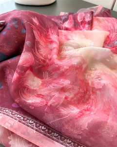 Detail of pink floral silk scarf showing jacquard texture and heart-patterned borders