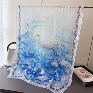Detail of elegant white and blue silk scarf with peacock print and floral pattern
