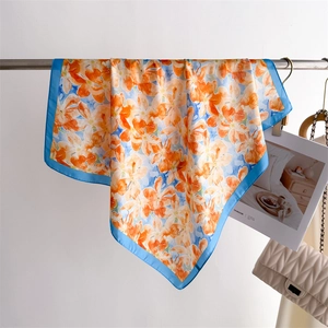 Carré de soie à imprimé floral orange et bleu avec un sac à main élégant assorti