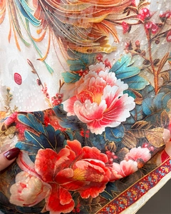 Close-up of silk scarf showing intricate peony floral print and phoenix wing textures