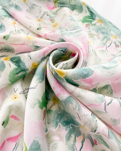 Détail macro d'un foulard en soie aux motifs floraux pastel avec des plis élégants