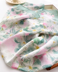 Gros plan détaillé du foulard en soie aux motifs floraux élégants roses et verts