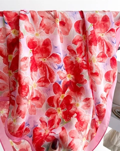 Gros plan d'un foulard en soie avec imprimé floral rouge et texture lisse et brillante