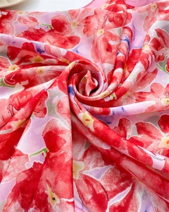 Détails d'un foulard en soie aux motifs floraux artistiques rouge et violet vif