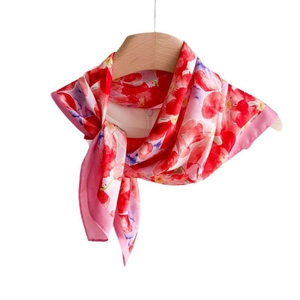 Carré en soie à imprimé floral magenta élégamment drapé sur un cintre en bois naturel