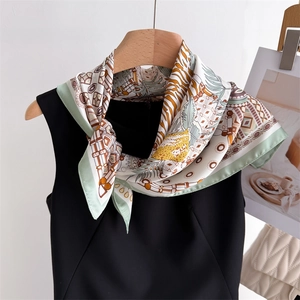 Detail of silk square scarf with tiger print and palm leaves worn on a neck