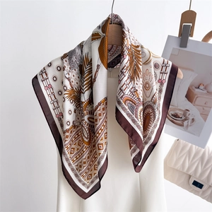 Bohemian silk scarf with ethnic feather prints displayed on a minimalist hanger