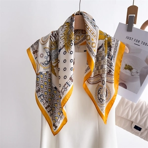 Exotic geometric print silk square scarf in ginger yellow draped over white dress