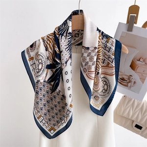 Detail of silk-feel scarf with geometric prints styled on a white dress