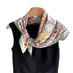 Elegant silk scarf with leopard print and geometric patterns worn on a black top
