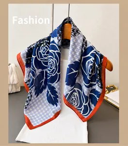 Detail van de blauwe sjaal met pied-de-poule en rozenpatroon met oranje bies