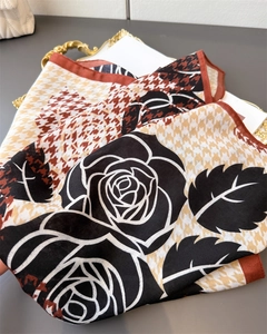 Detailweergave van zijden sjaal met bloemenprint en een chic houndstooth patroon