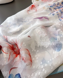 Macro detail of sheer white floral scarf fabric with jacquard weaving and vibrant prints