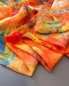 Detail of vibrant artistic floral print silk scarf with luxury draped texture and fringe