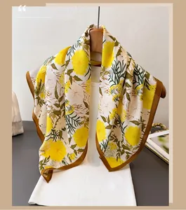 Detail of floral print scarf with yellow flowers and brown hem on a wooden hanger