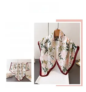 Detail of floral silk scarf with burgundy edges and elegant satin texture finish
