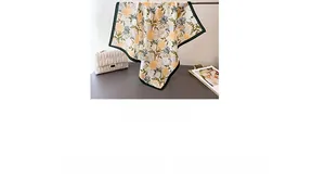 Detail of floral print silk scarf with distinctive black borders and orange flower pattern