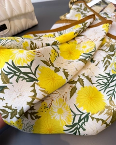 Detail of yellow floral pattern and herringbone texture on premium silk-like scarf