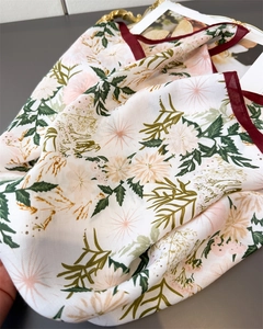 Macro shot of floral silk scarf featuring cream daisy print and red contrast border