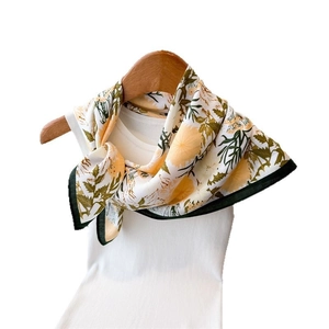 Floral print silk scarf with yellow chrysanthemum patterns on white ribbed tank top